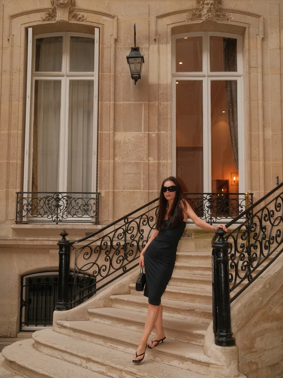 Diana wearing a dark dress on a Paris staircase